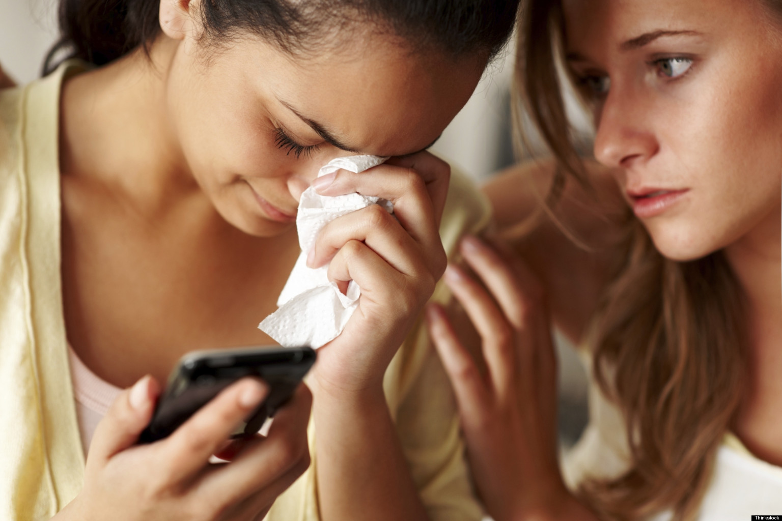 women-crying-together-cell-phone